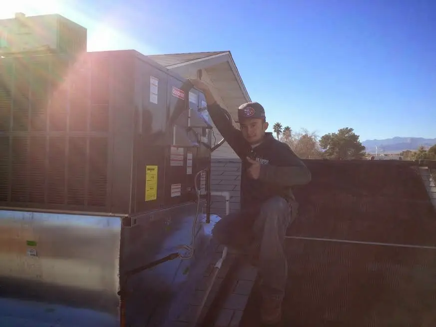 HVAC technician performing AC Tune-Up on a rooftop unit in Cheney